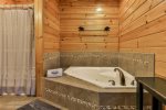 Main level master private bathroom with walk-in shower and jetted tub
